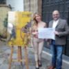 El artista onubense, Javi Cástulo, recibe los 4.000 euros de mano de la directora de la Fundación AZVI, Pilar Krant
