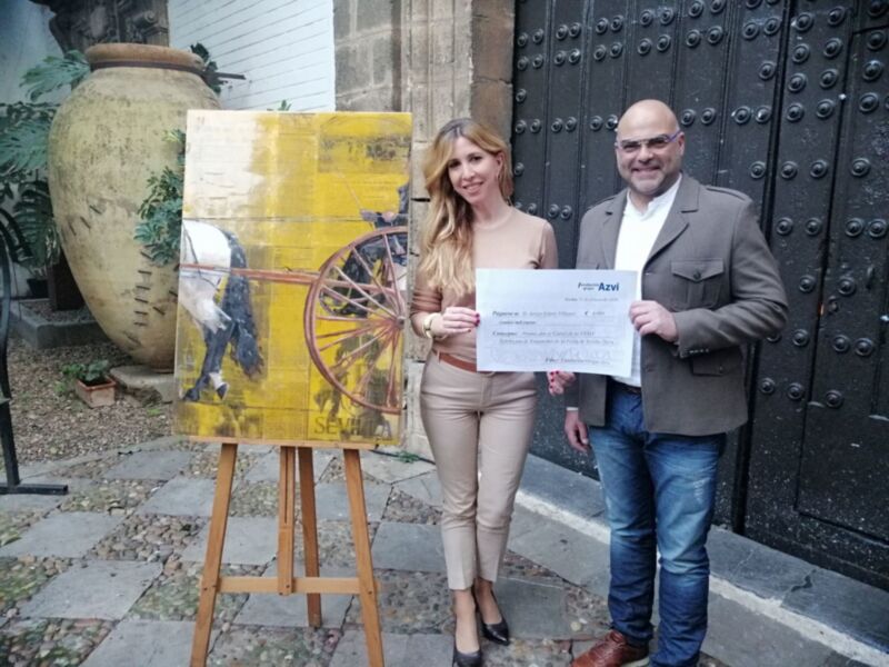 El artista onubense, Javi Cástulo, recibe los 4.000 euros de mano de la directora de la Fundación AZVI, Pilar Krant