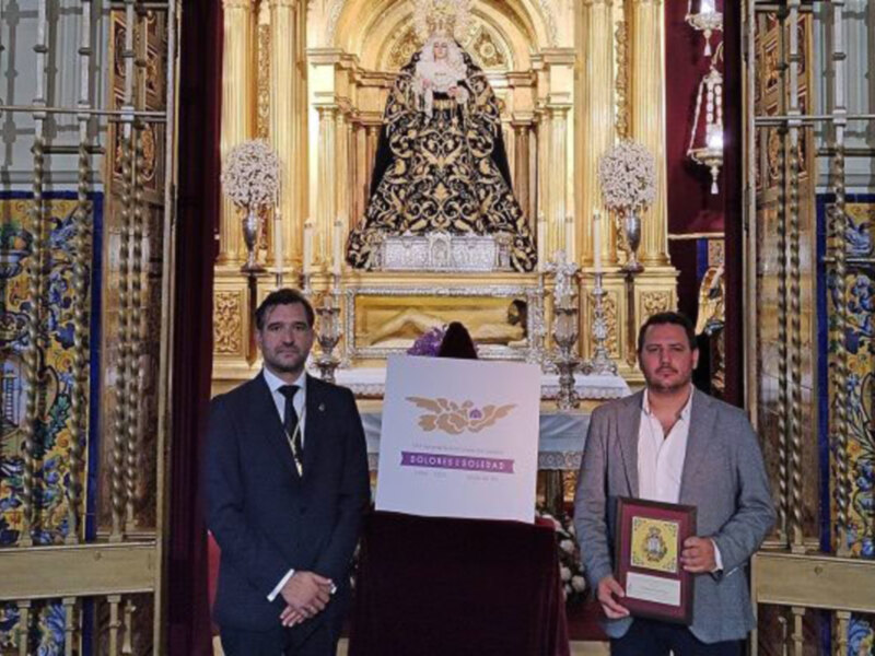 El hermano mayor de la Soledad de Alcalá del Río, Luis Carlos Velázquez, y el diseñador del logotipo, Miguel Ferrera, en su presentación.