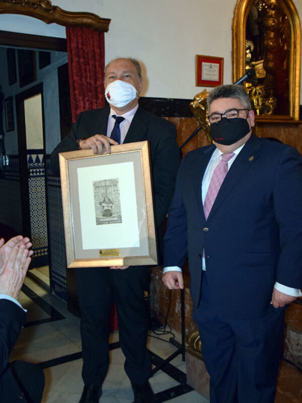 La corporación del Sábado Santo, hizo entrega de un grabado conmemorativo al director del Boletín de las Cofradías de Sevilla, Rafael Jiménez Sampedro