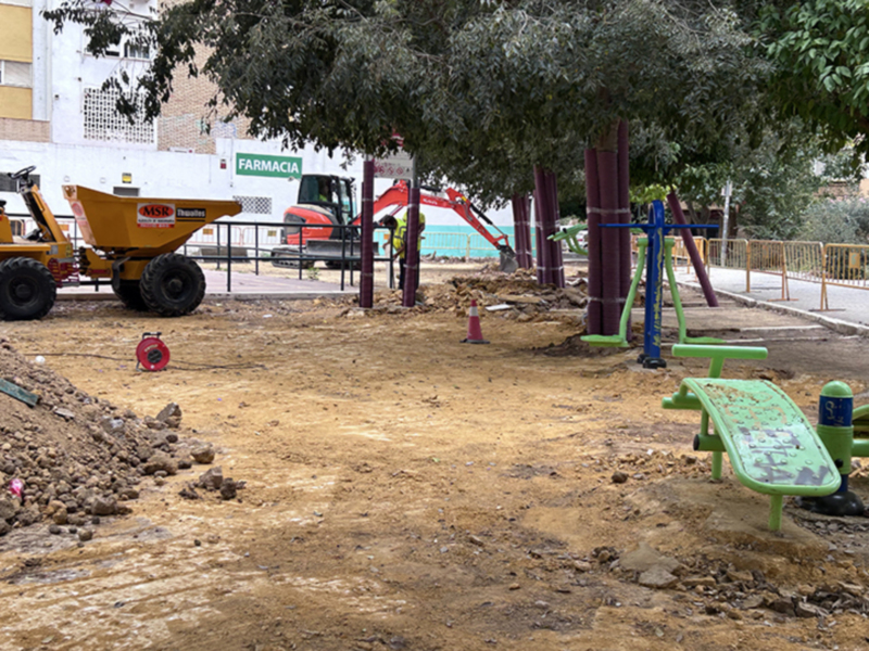 Área de construcción con maquinaria y equipamiento de ejercicio al aire libre en un parque.