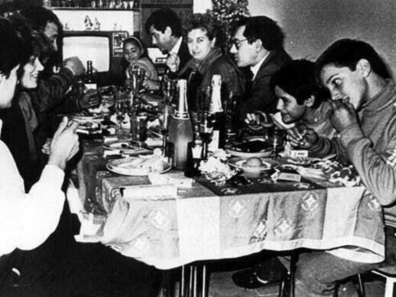 Una reunión familiar disfrutando de una cena navideña alrededor de una mesa festiva.