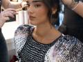 Una modelo, en maquillaje en el backstage abierto al público.